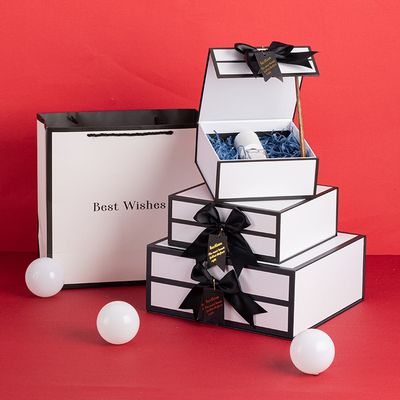 黒い縁およびリボンの弓が付いている堅く白い磁気ボール紙のギフト用の箱